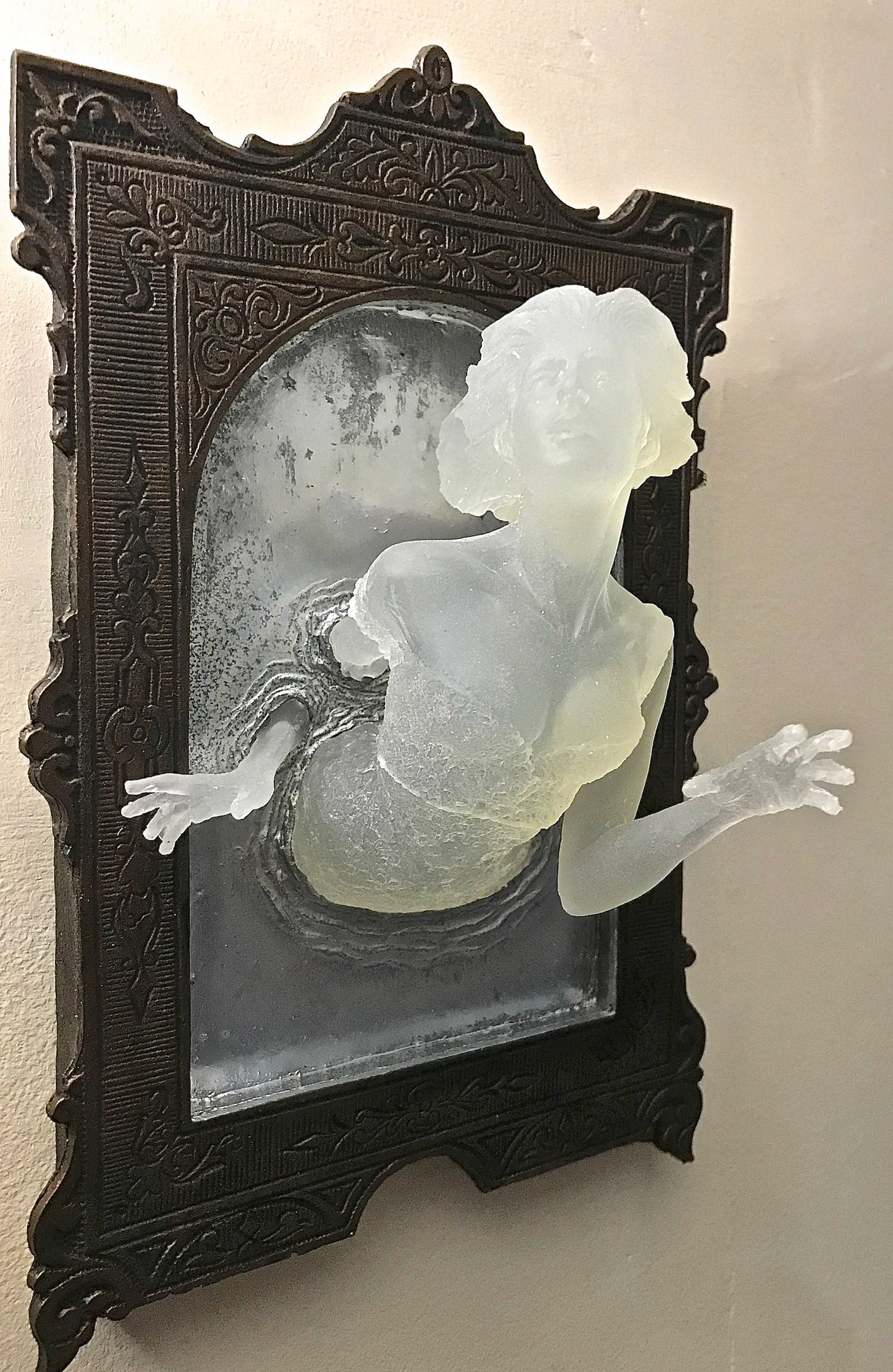 SPOOKY WALL SCULPTURES OFVICTORIAN GHOSTS EMERGINGFROM A MIRROR