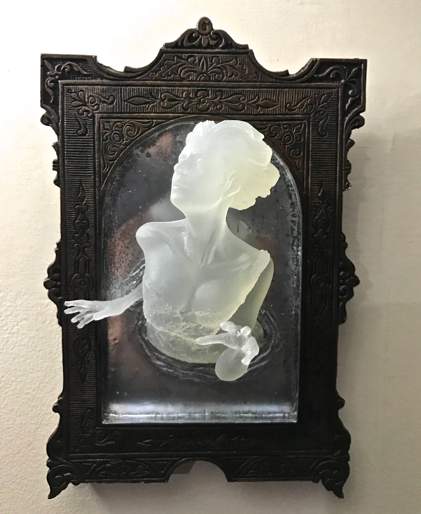 SPOOKY WALL SCULPTURES OFVICTORIAN GHOSTS EMERGINGFROM A MIRROR